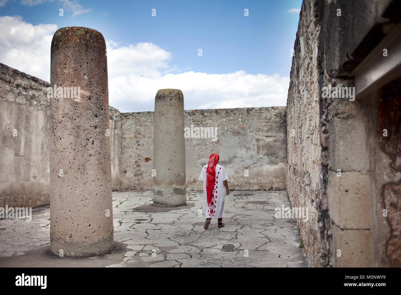 Eine Frau das Tragen von Oaxaca indigenen Kleidung Spaziergänge in Mitla archäologische Stätte in Oaxaca, Mexiko Stockfoto