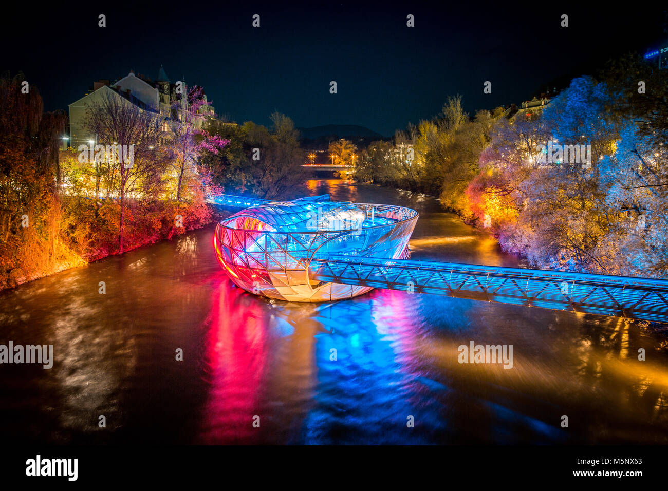 Schöne Panorama der berühmten Grazer Murinsel, eine künstliche schwimmende Insel in der Mitte der Mur bei Nacht beleuchtet, Graz, Steiermark, Stockfoto