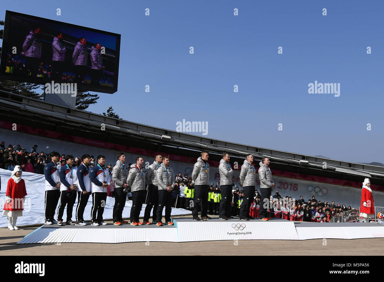 25 Februar 2018, Südkorea, Pyeongchang, Olympics, Bob, vier - Mann Bob, Mens, 4. Runde, Alpensia Sliding Center: Die Teams von Pilot Yunyong Wong von Südkorea (L-R), Pilot Nico Walther von Deutschland und Francesco Friedrich von Deutschland stehen auf dem Podium. Die Teams von Wong und Walther gemeinsam die Silbermedaille gewann, team Friedrich gewann Gold. Foto: Tobias Hase/dpa Stockfoto