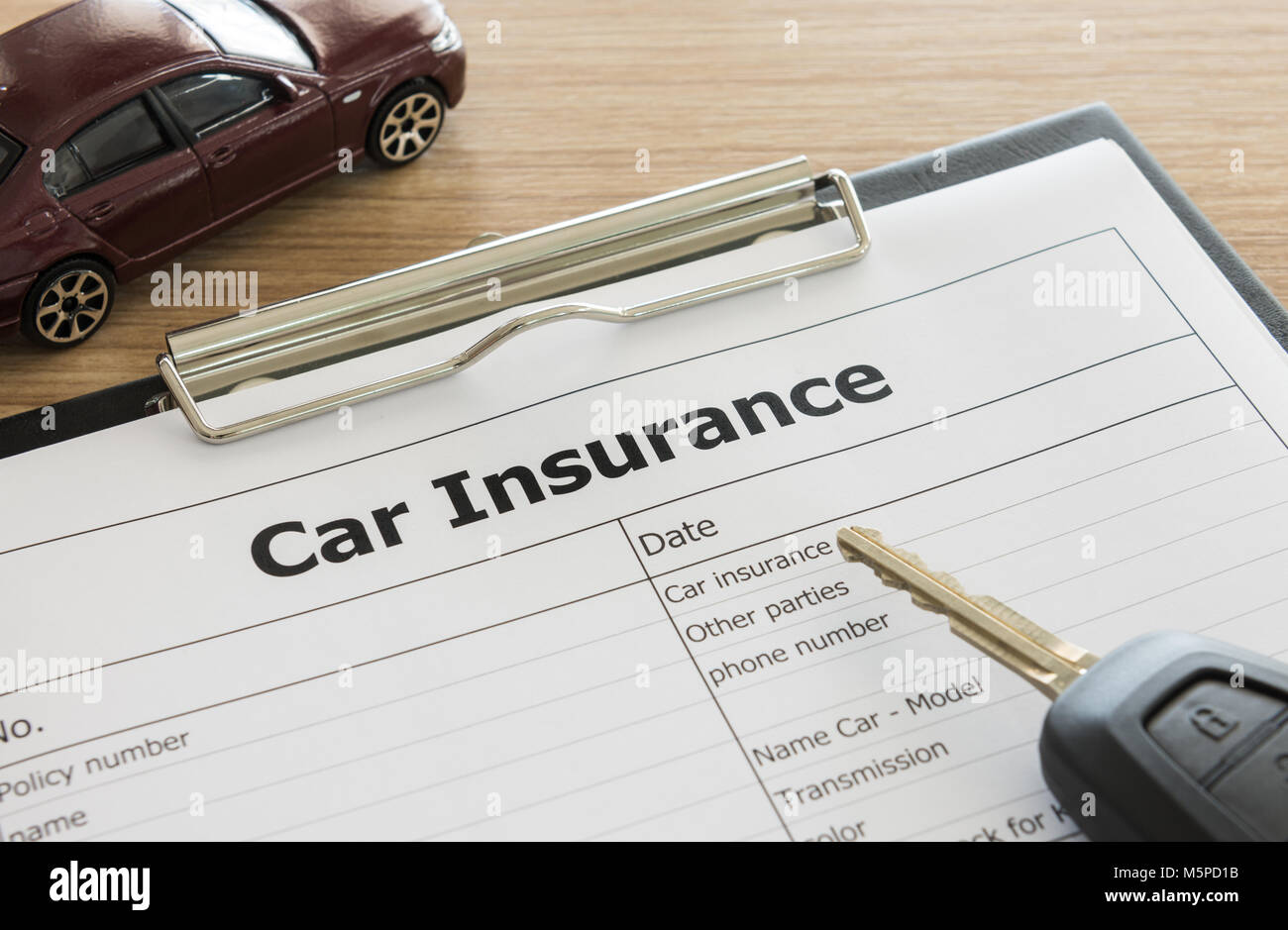 Auto Versicherung Anmeldeformular mit dem Auto Modell und remote auf dem Schreibtisch. Stockfoto