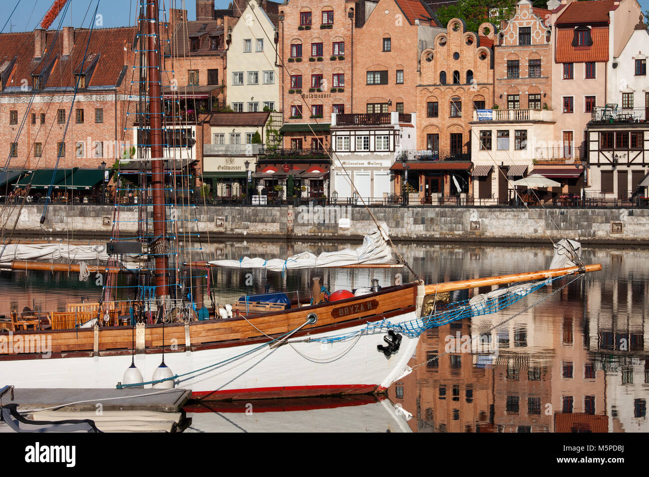 Alte Hafenstadt Danzig in Polen, Reihe der Altstadt Häuser an der historischen Waterfront und Segelboot auf einem Fluss Stockfoto