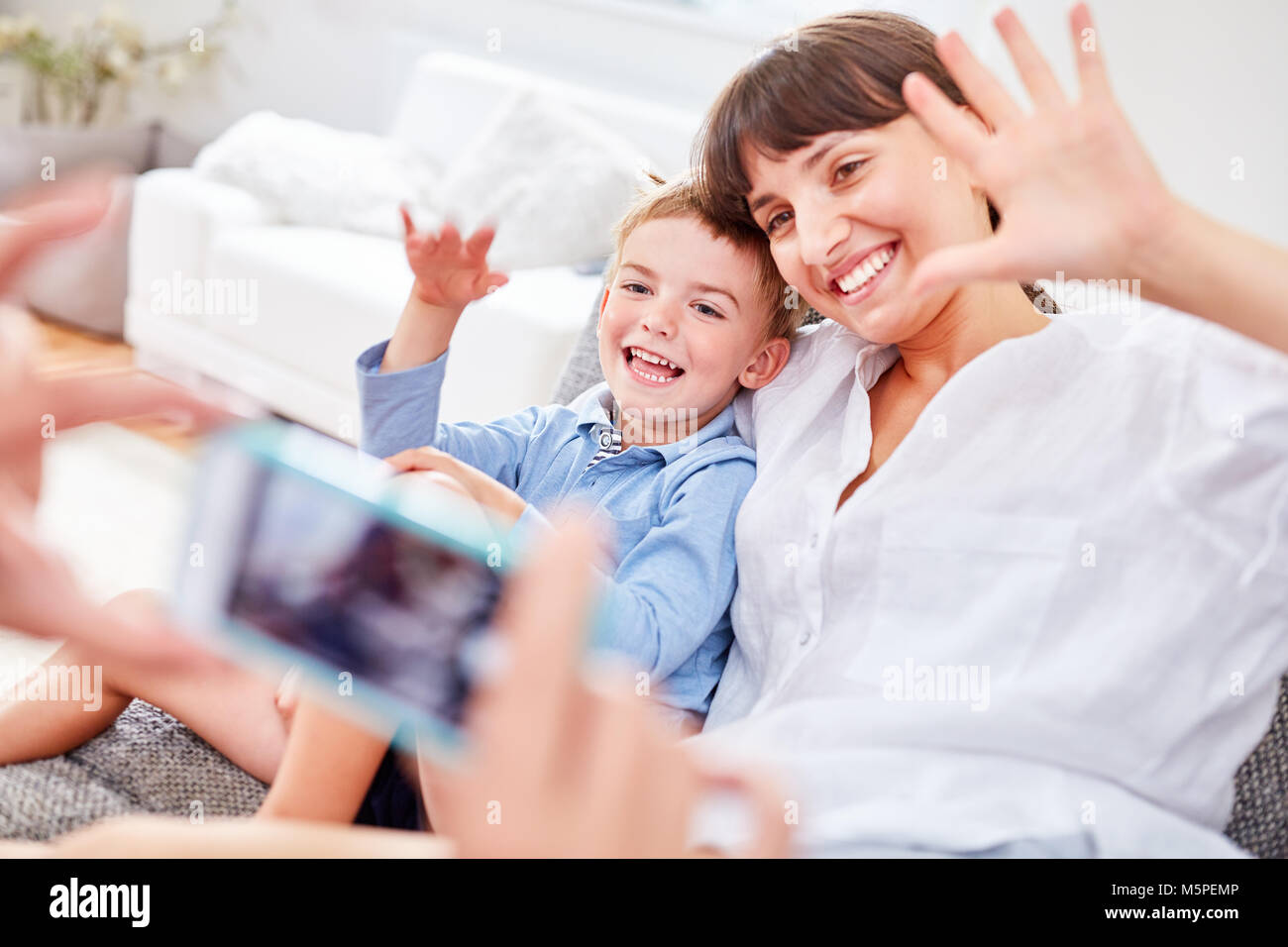 Mutter und Sohn posieren für ein Snapshot mit dem Smartphone Kamera Stockfoto