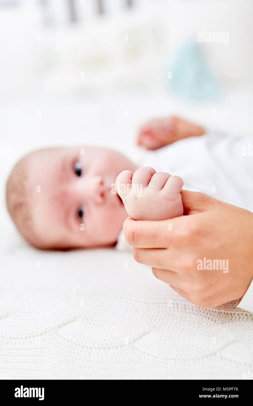 Neugeborenes Baby erreicht für den Daumen von Vater mit Hand Stockfoto