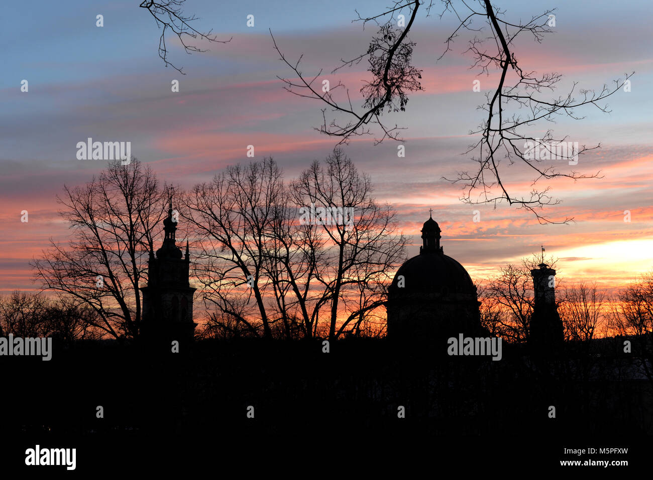 Korniakta Turm, Kirche der Heiligen Eucharistie (ehemaliges dominikanisches Kloster Kirche) und Lemberg Rathausturm siluete bei Sonnenuntergang, Lviv, Ukraine Stockfoto