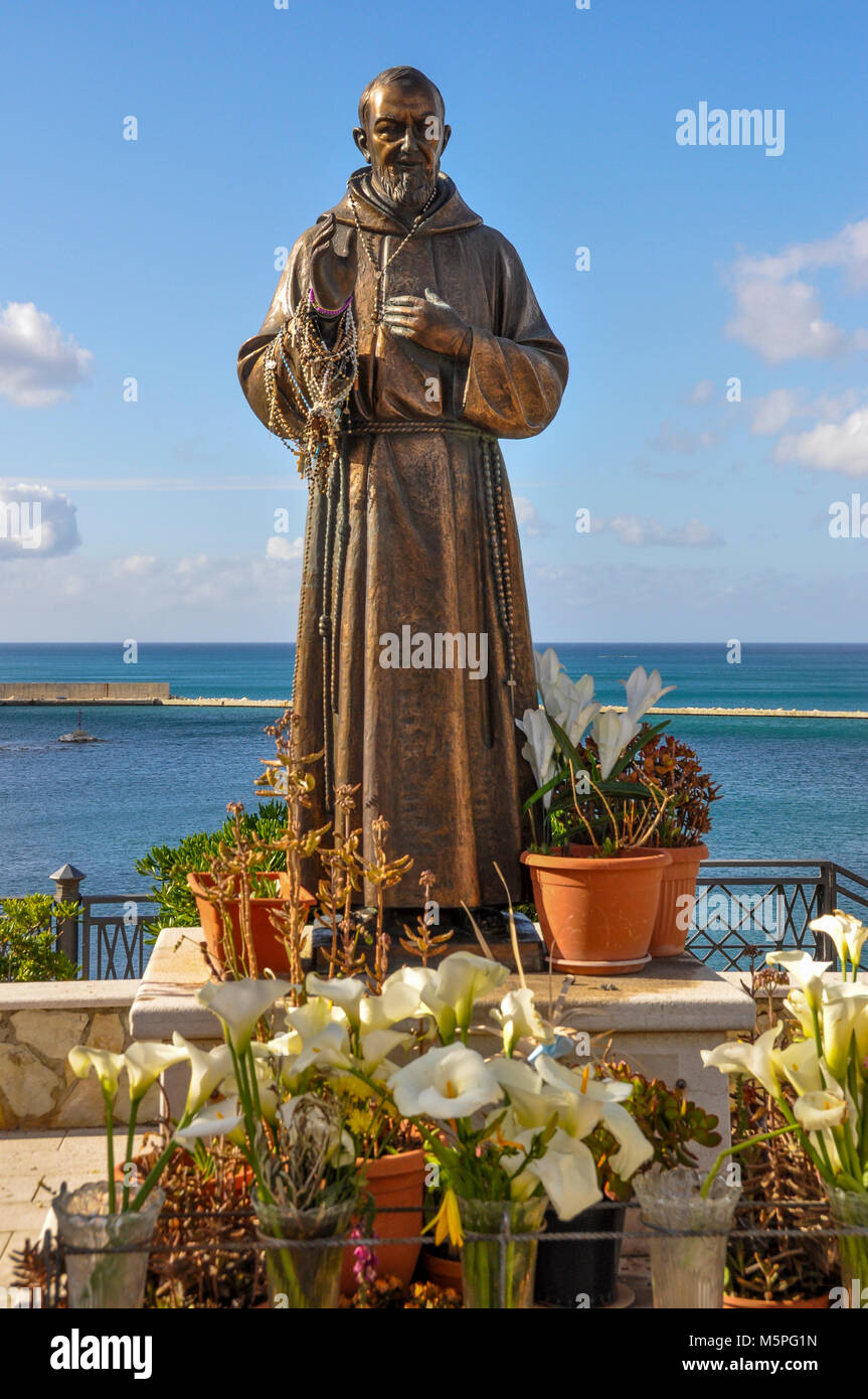 Bronzestatue des heiligen Pio im Hafen von Castellammare del Golfo, Sizilien, Italien. Stockfoto