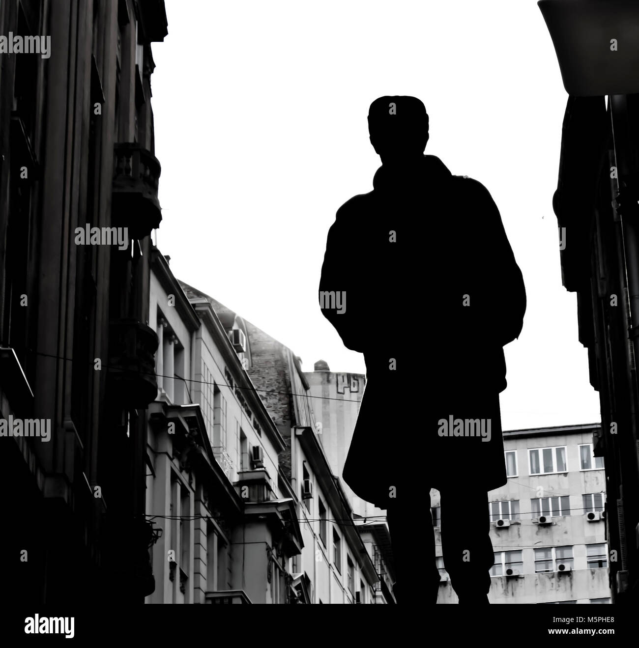 Silhouette eines Mannes wandern und Stadt Architektur in Schwarz und Weiß niedrigen Winkel viewperspective Stockfoto