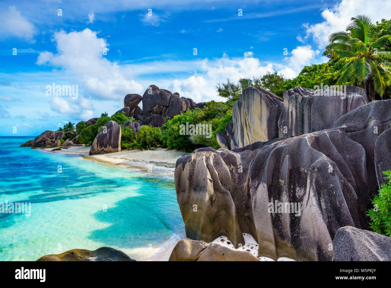 Unglaublich malerische Paradise Beach. Granitfelsen, weißer Sand, Palmen, türkisfarbenes Wasser am tropischen Strand Anse Source D'Argent, La Dique, Seychellen Stockfoto