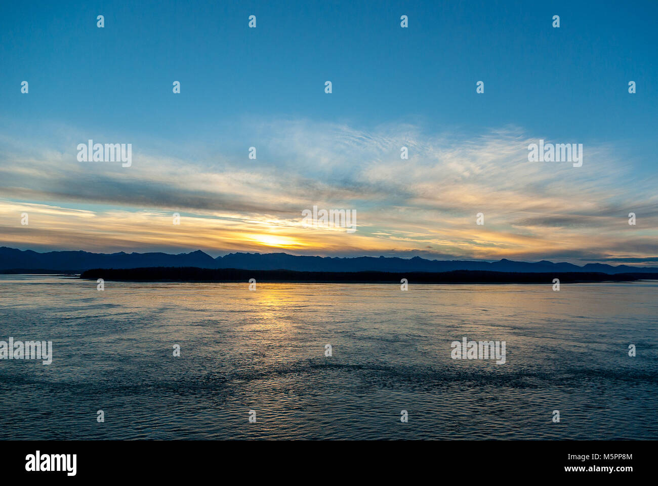 Querformat der Sonnenaufgang auf dem Glacier Bay, Alaska mit Wolken, die Bucht und die Berge am Horizont Stockfoto