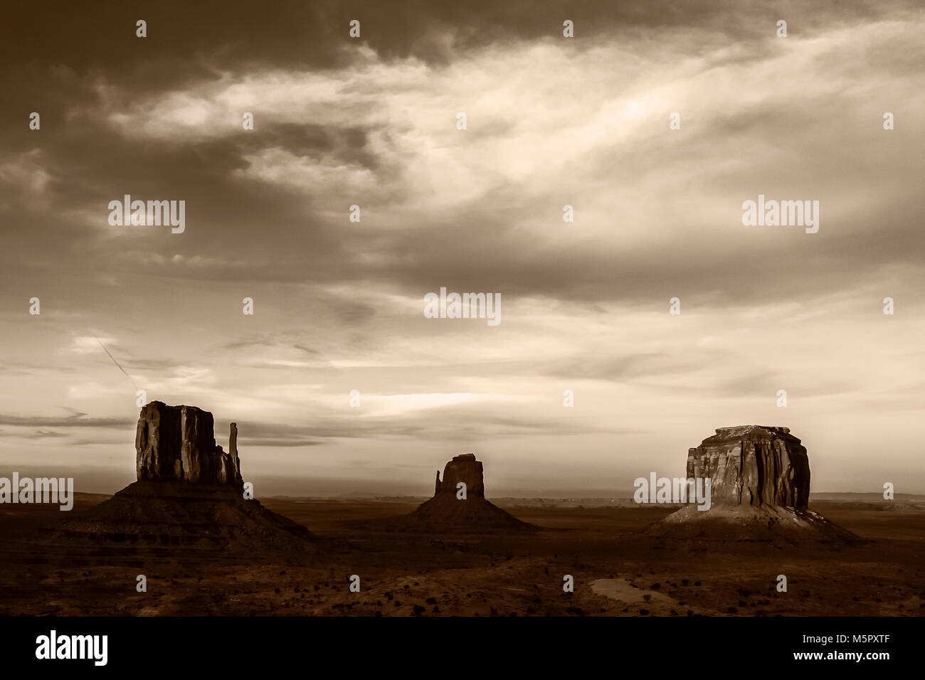 Monochrom von West und Ost Fäustling und die Merrick Buttes im Monument Valley Navajo Tribal Park bei Sonnenuntergang, Arizona. Stockfoto