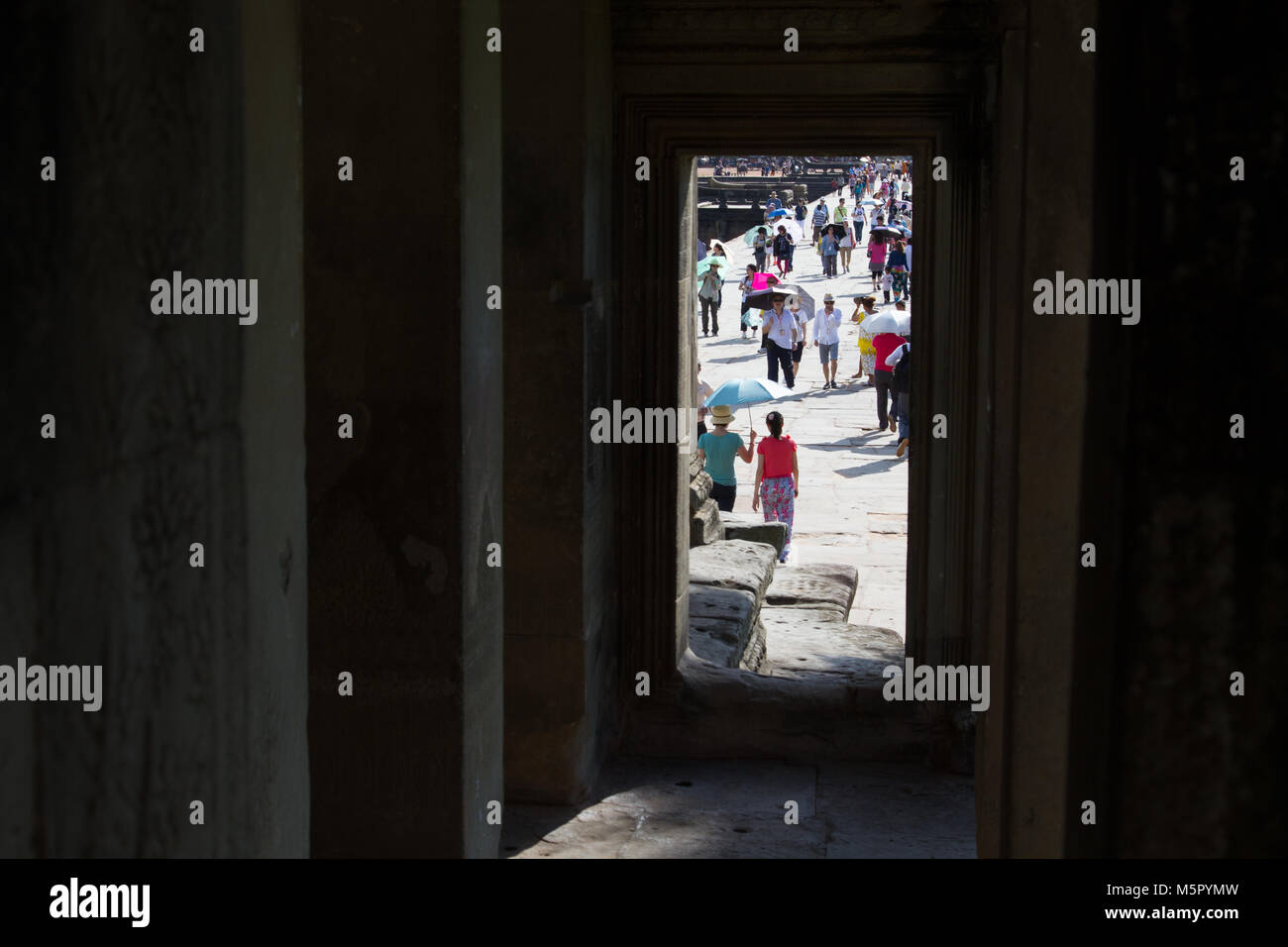Massen von Touristen, die in Angkor Wat in Kambodscha, in Südostasien, wie durch eine Tür gesehen. Stockfoto