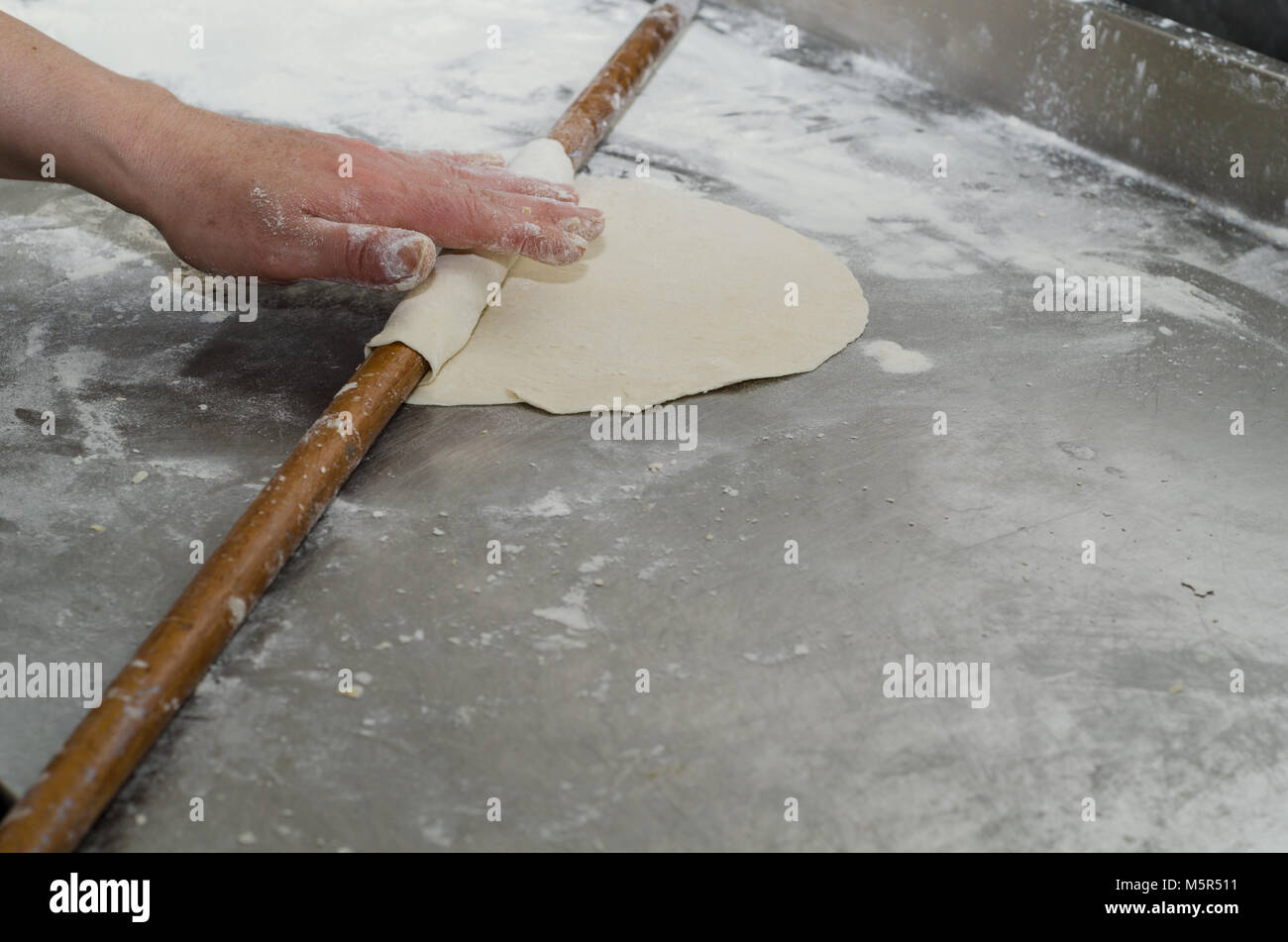 Die Hand der Frau öffnete die Torte Teig mit einem Nudelholz, Ansicht von oben. Stockfoto