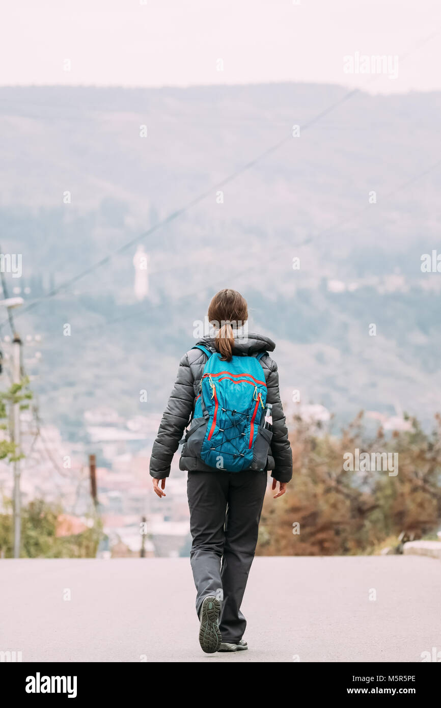 Tiflis, Georgien. Junge Frau Backpacker Traveller Wandern in der Nähe von Berge im Herbst Tag. Ansicht von hinten. Stockfoto