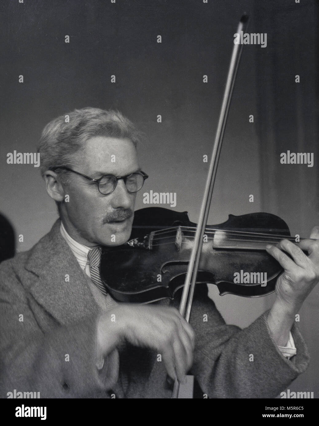 1950er Jahre, historische, Geigerin, eine Nahaufnahme zeigt einen Herrn in Jackett und Krawatte Violine zu spielen, England, UK. Stockfoto