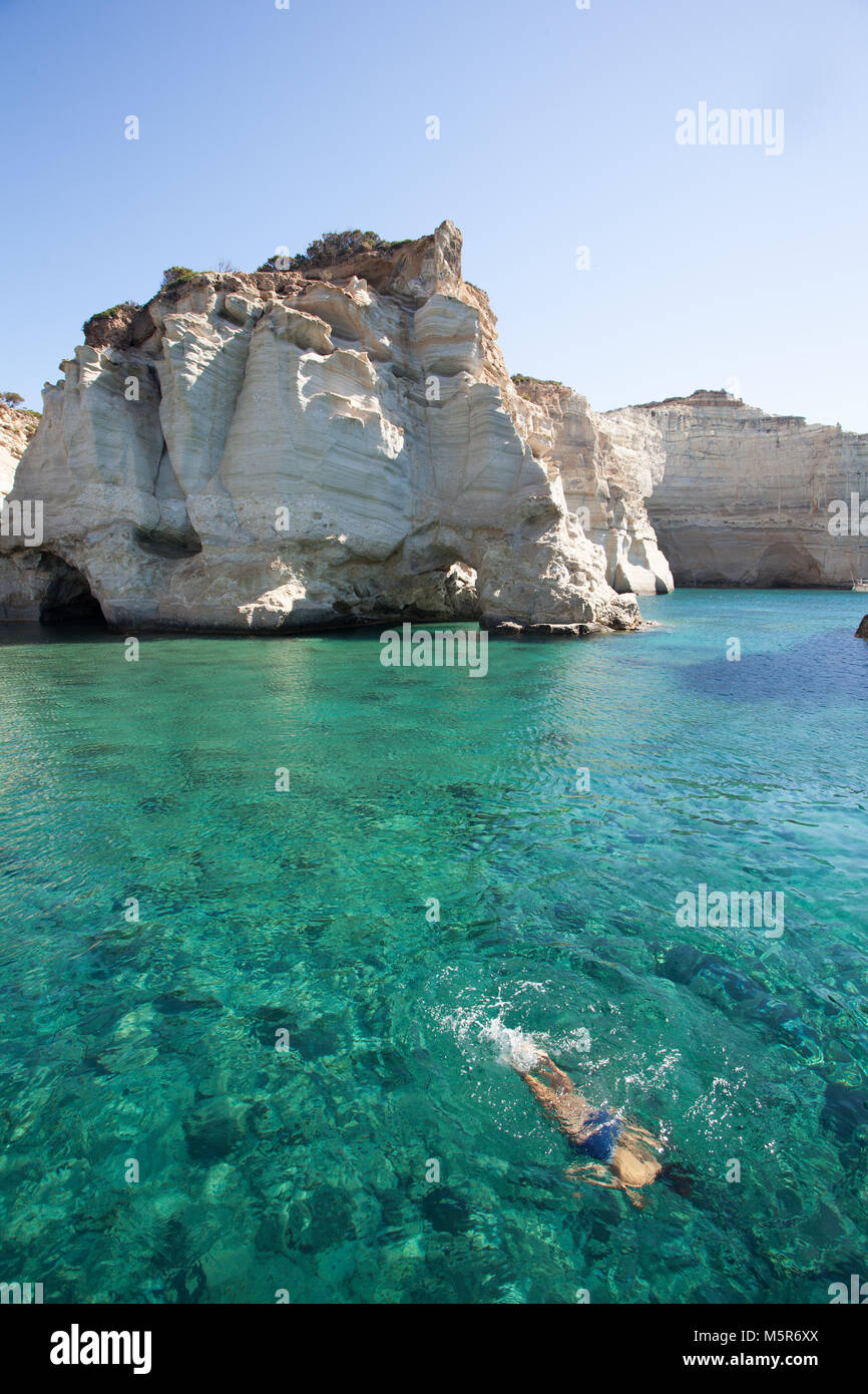 Ein Junge Tauchen im kristallklaren Wasser der Insel Milos, während der täglichen Bootstour, Milos, Griechenland Stockfoto