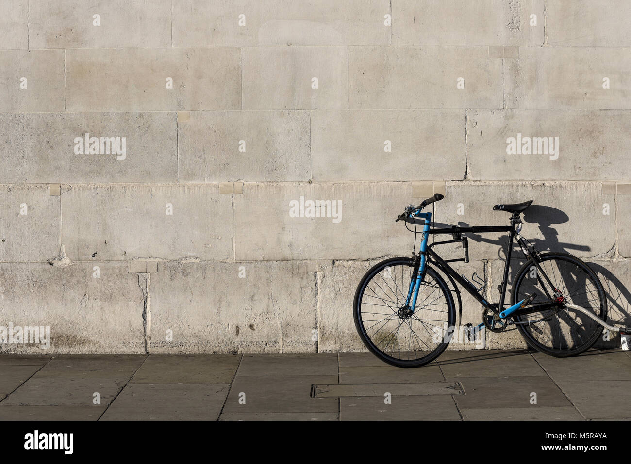 Fahrrad gegen eine leere, einfache Wand. Einfacher Hintergrund. Zyklus. Motorrad isoliert Stockfoto