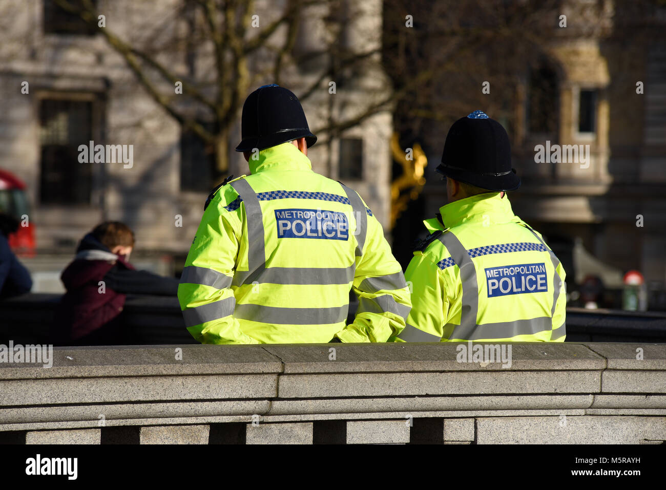 Die Metropolitan Police Officers in Trafalgar Square, London, über Mitglieder der Öffentlichkeit. Platz für Kopie Stockfoto