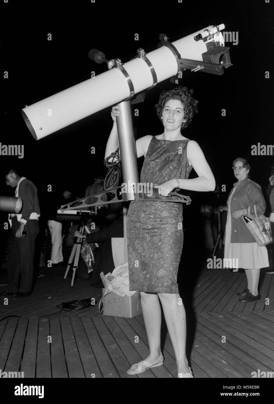 Eine starke Frau hefts ein Spiegelteleskop, Ca. 1961. Stockfoto