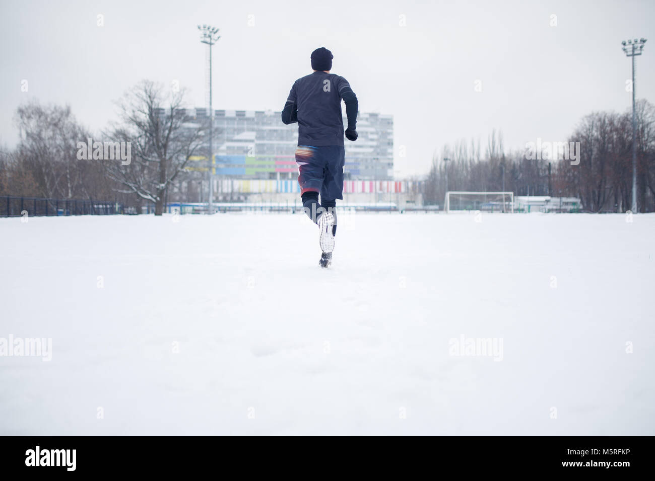 Foto der laufenden Athleten in schwarzer Kleidung auf Stadium Stockfoto