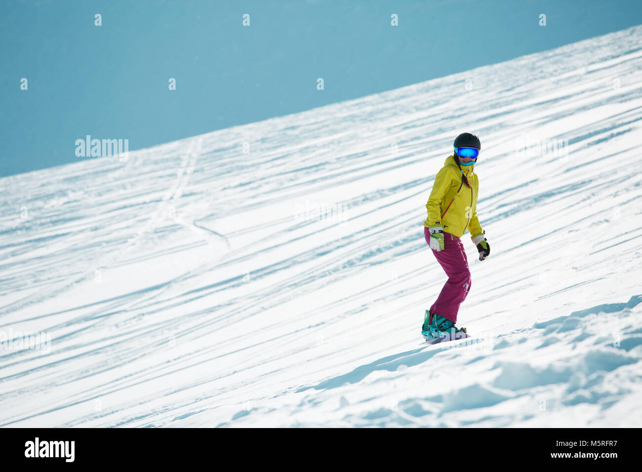 Bild von Sport Frau das Tragen von Helm und Maske, Snowboarden vom Berghang Stockfoto