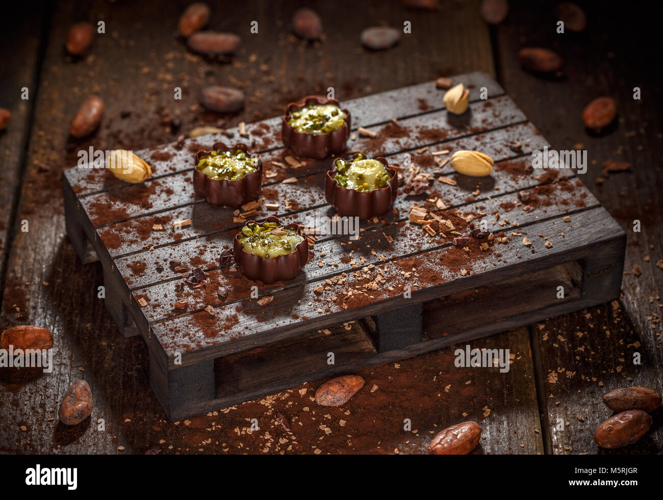 Luxus Schokolade Bonbons mit Pistazien auf dunklen Holzpalette eingerichtet Stockfoto