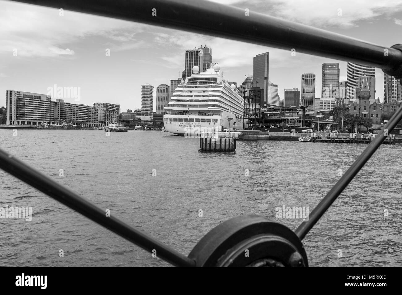 Monochrome Blick auf Kreuzfahrtschiff Crystal Serenity, Sydney's Overseas Passenger Terminal, Circular Quay und CBD skyine Schuß durch eiserne Geländer. Circ. Stockfoto