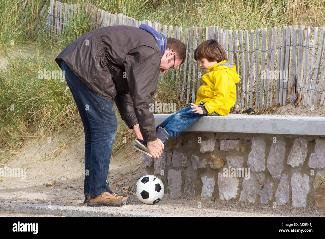 Vater und Sohn nach Fußball spielen am Strand. Stockfoto