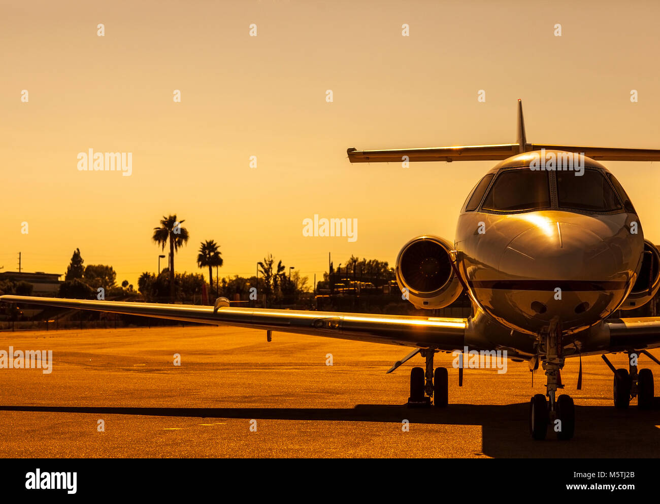 Luxury Private Jet ist auf einem Flugplatz bei der wunderschönen Golden Sunset geparkt Stockfoto