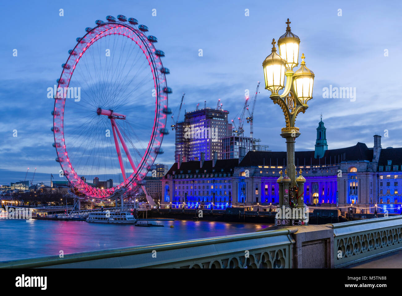 Das London Eye und der County Hall in der Morgendämmerung von Westminster Bridge gesehen Stockfoto