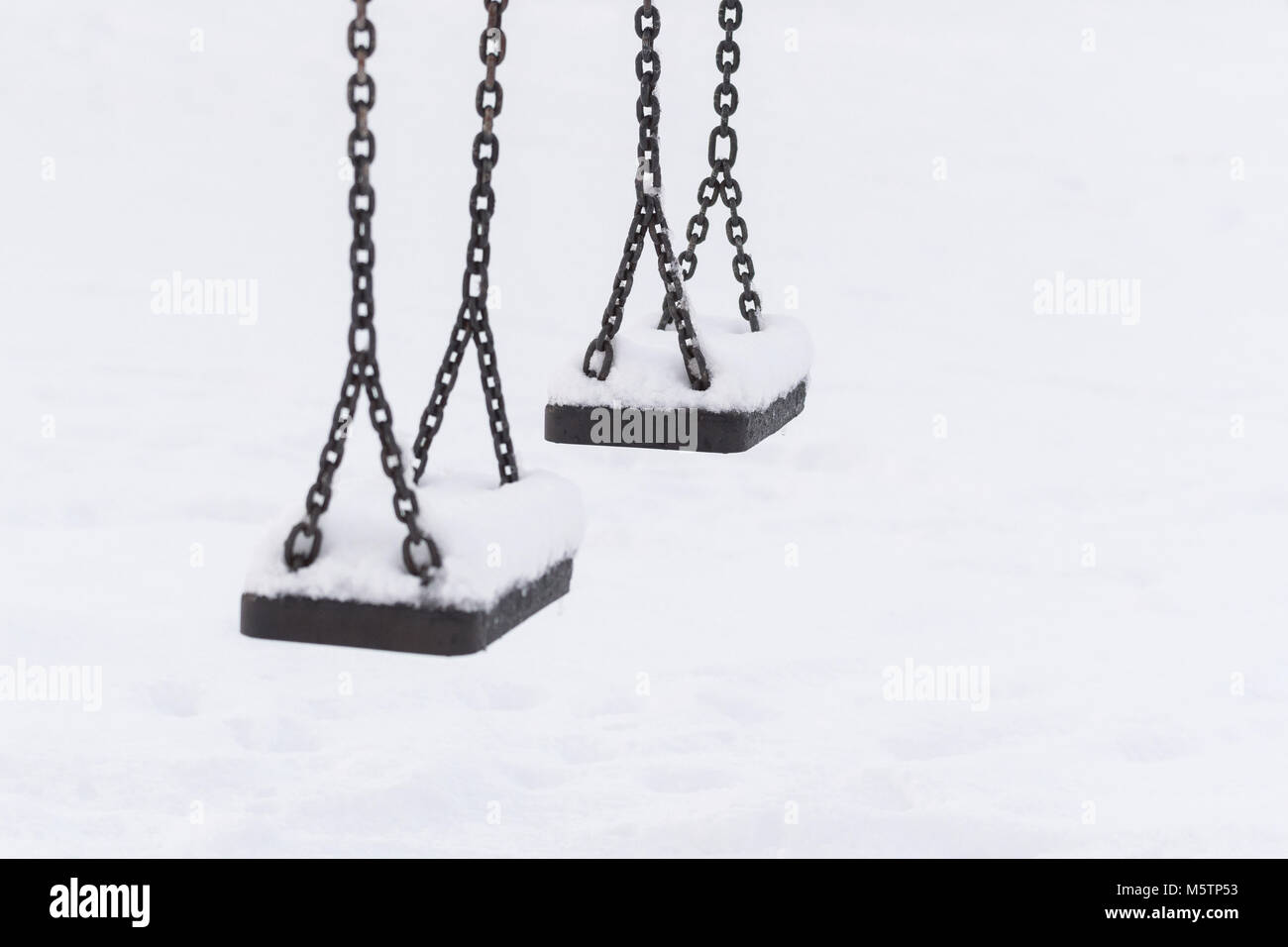 Zwei leere Park schaukeln Sitze im Schnee Stockfoto