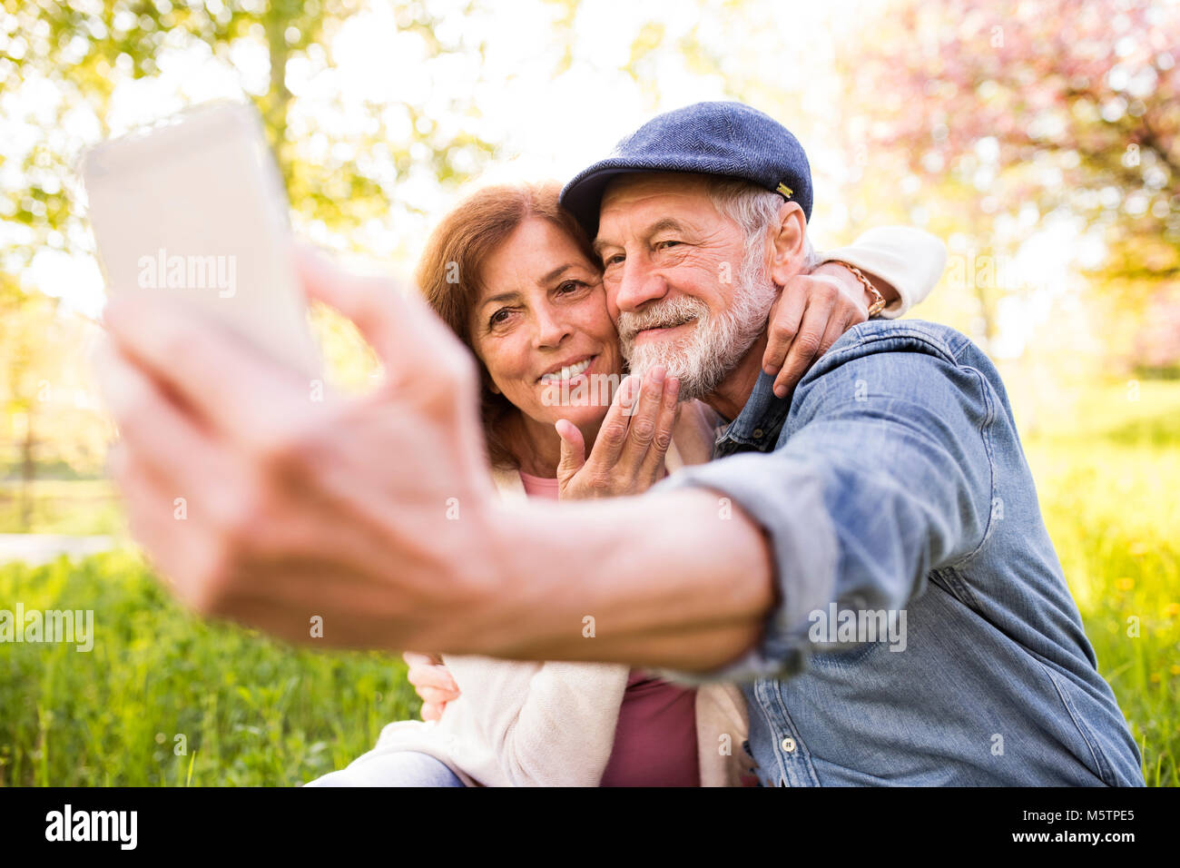 Senior Paar mit Smartphone außerhalb im Frühjahr die Natur. Stockfoto