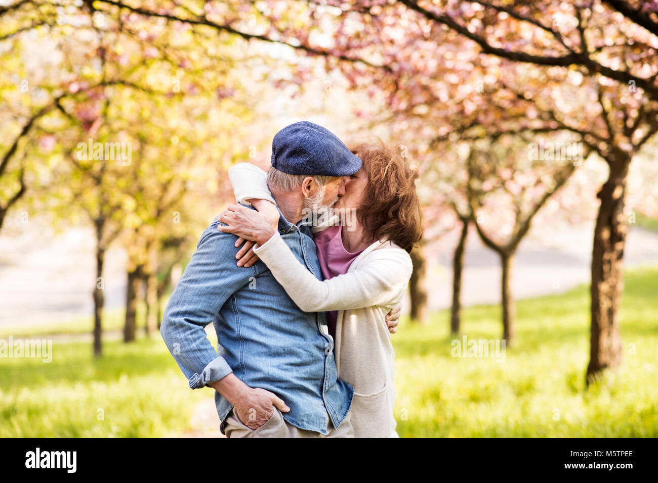 Senior Paar in Liebe außerhalb im Frühjahr die Natur zu küssen. Stockfoto