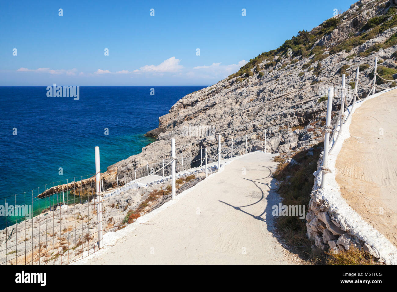An der Küste zu Fuß Straße mit Kette Zäune. Griechische Insel Zakynthos im sonnigen Sommertag Stockfoto