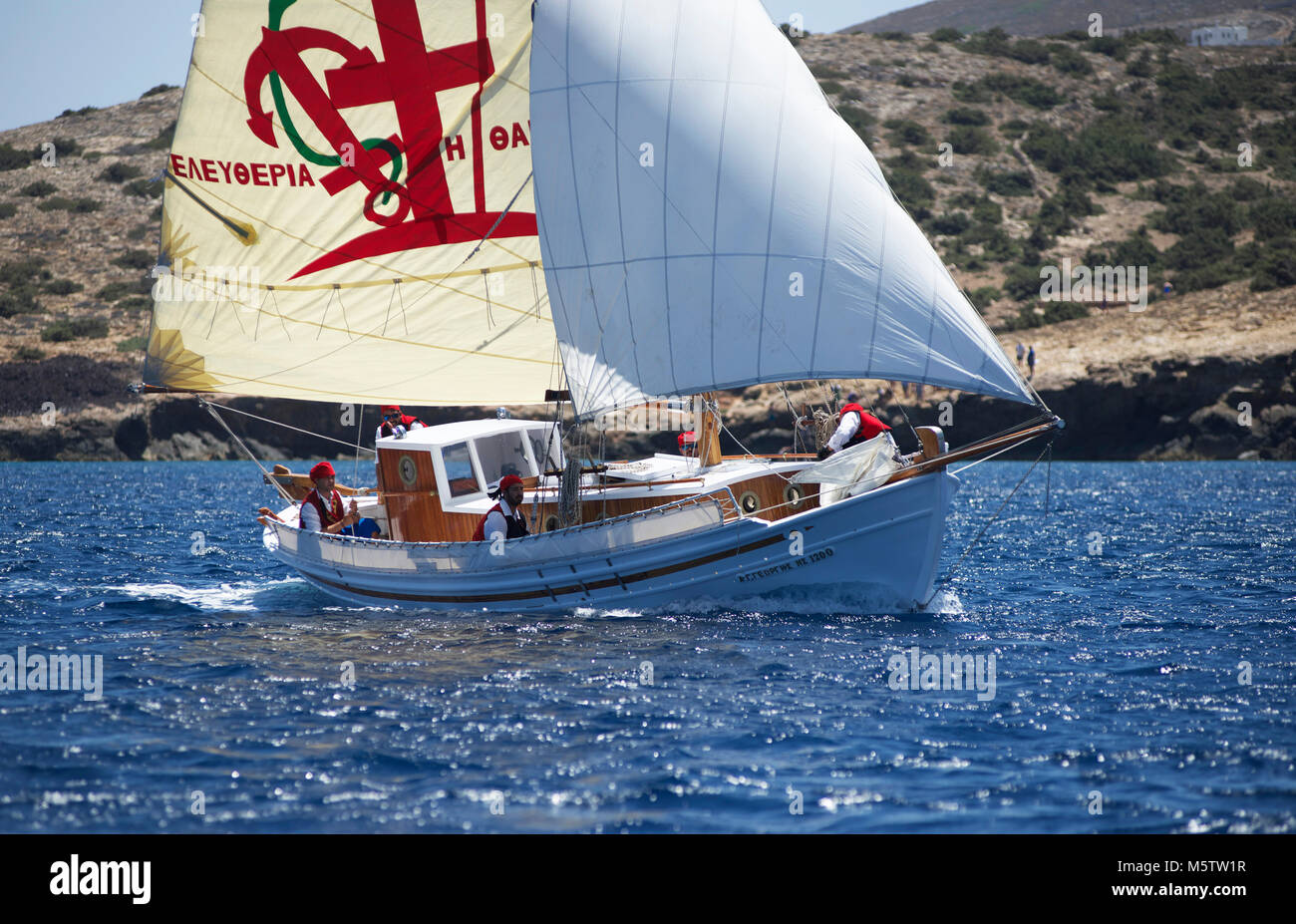 Traditionelles griechisches Fischerboot Agios Georgios aus Segeln in den Kykladen Syros Classic Yacht Race. Die Crew tragen Tradition Kostüm. Stockfoto
