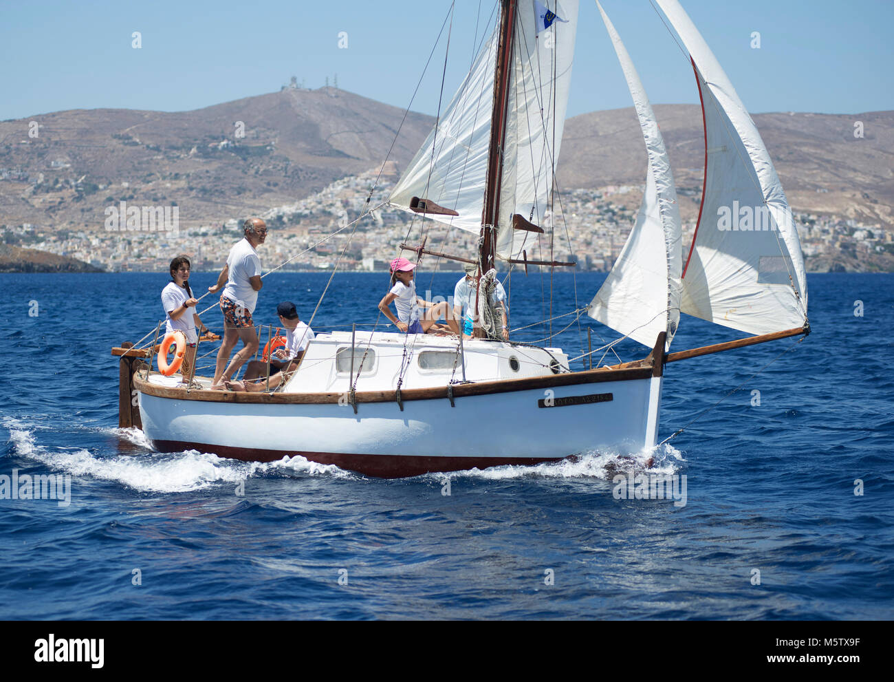 Miltos Sakelariou (stehend) und Familie und genießen Sie einen Tag auf ihre Fiberglas cutter Kivoto (die Arche) von Ermoupoli auf der Insel Syros, Griechenland. Stockfoto
