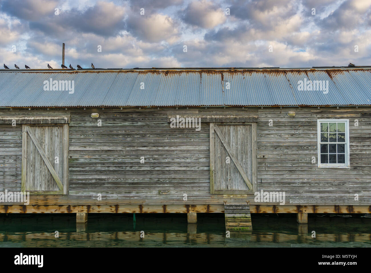 USA, Florida, alte Bootshaus im Hafen mit cloudscape und Wasser Reflexionen Stockfoto