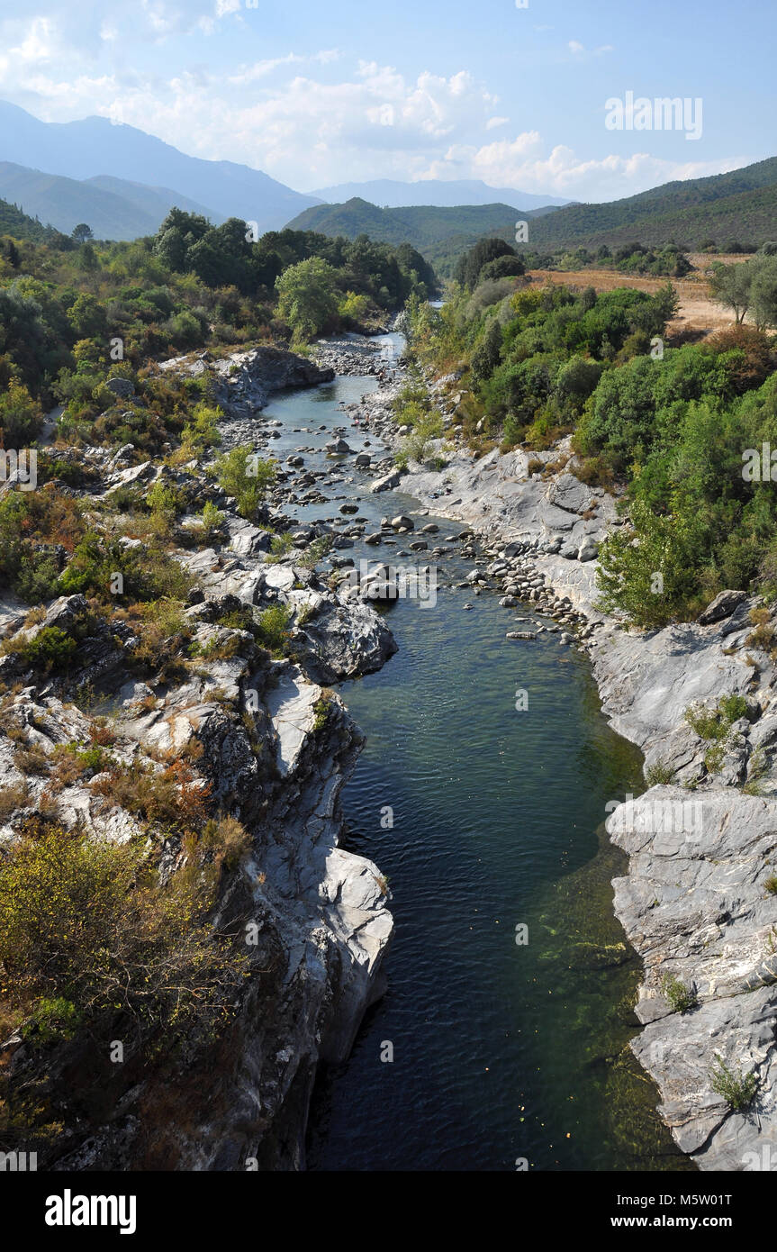 Blick auf eine korsische Schlucht und einen Fluss mit Berg- und Waldhintergrund. Aufgenommen auf der Insel Korsika Stockfoto