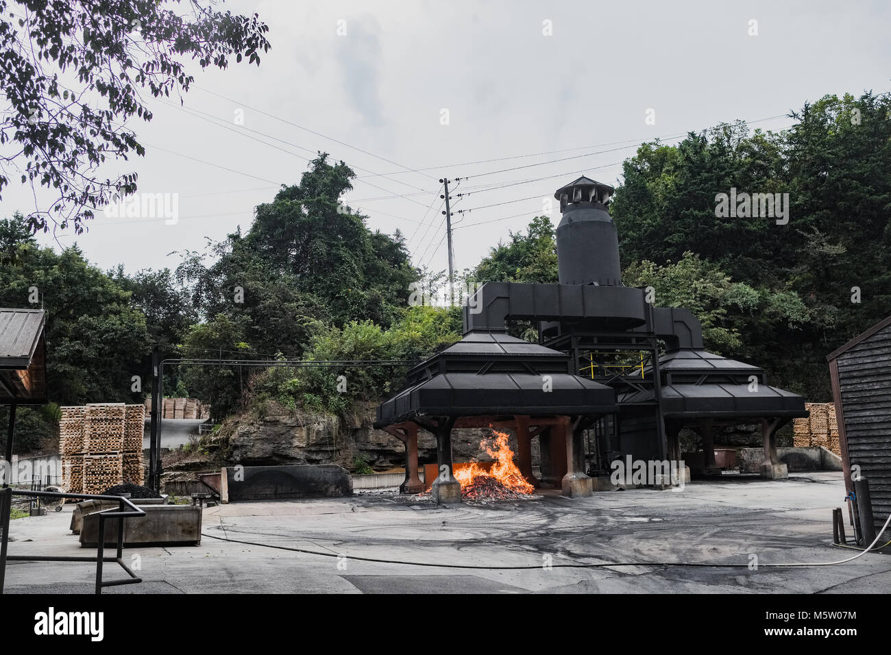 Das Verbrennen von Holz stapeln und eine Kohle Holz Feuer an der Jack Daniels Destillerie, Lynchburg, Tennessee, Nord Amerika Stockfoto
