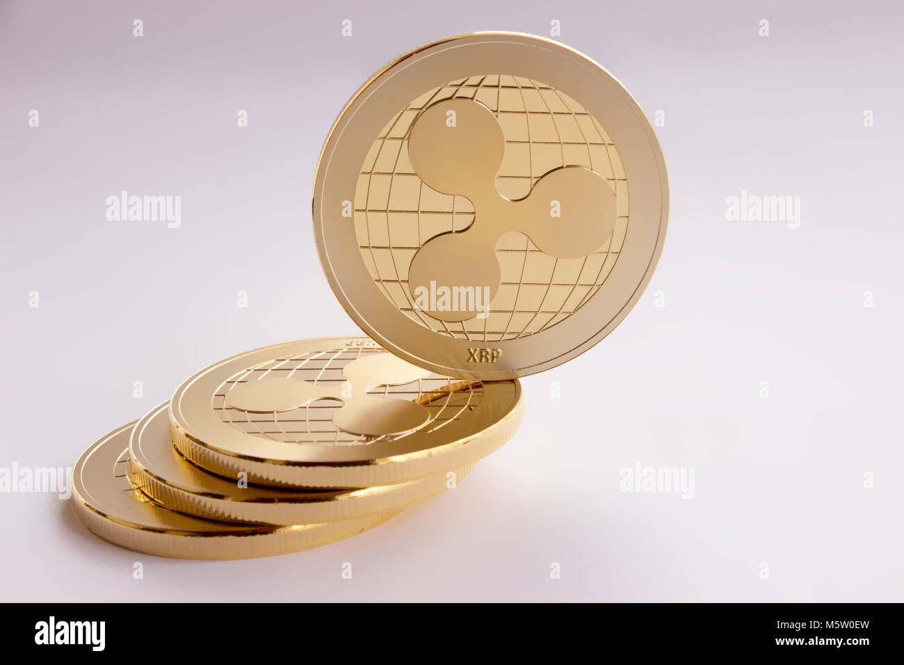 Auf den weißen Hintergrund sind Goldmünzen eines digitalen crypto Währung - restwelligkeit xrp. Auf der schiefen Ebene aus drei Münzen auf einer Seite platziert, t Stockfoto