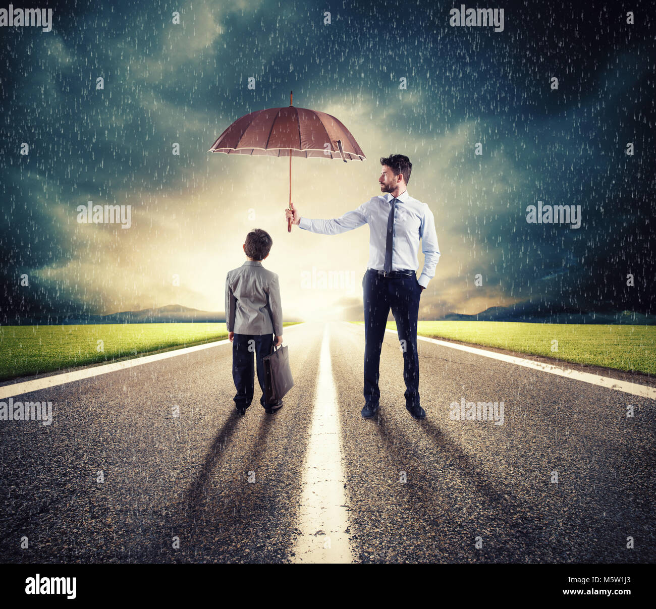 Geschäftsmann mit Regenschirm, ein Kind zu schützen. Konzept der Jungen Wirtschaft und Anlaufschutz Stockfoto