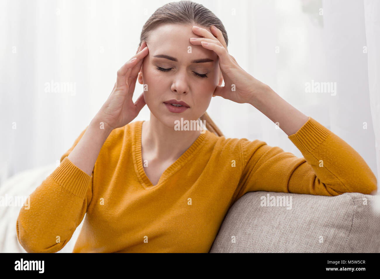 Schmerzhafte junge Frau massieren Kopf Stockfoto