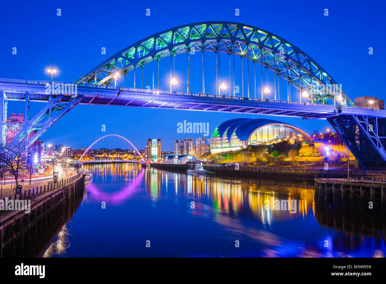 Newcastle upon Tyne Bridge, Aussicht bei Nacht der legendären Tyne Bridge mit der Gebäude- und Sage Gateshead Millennium Bridge in der Ferne, England, Großbritannien Stockfoto