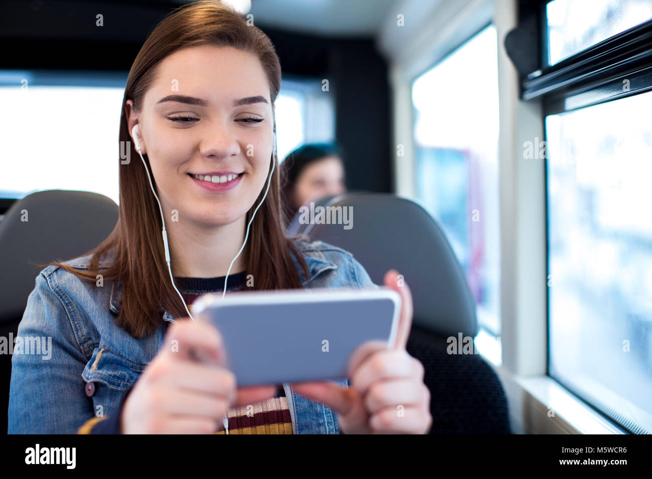 Frau beobachten Film auf Mobiltelefon während der Fahrt zur Arbeit Stockfoto