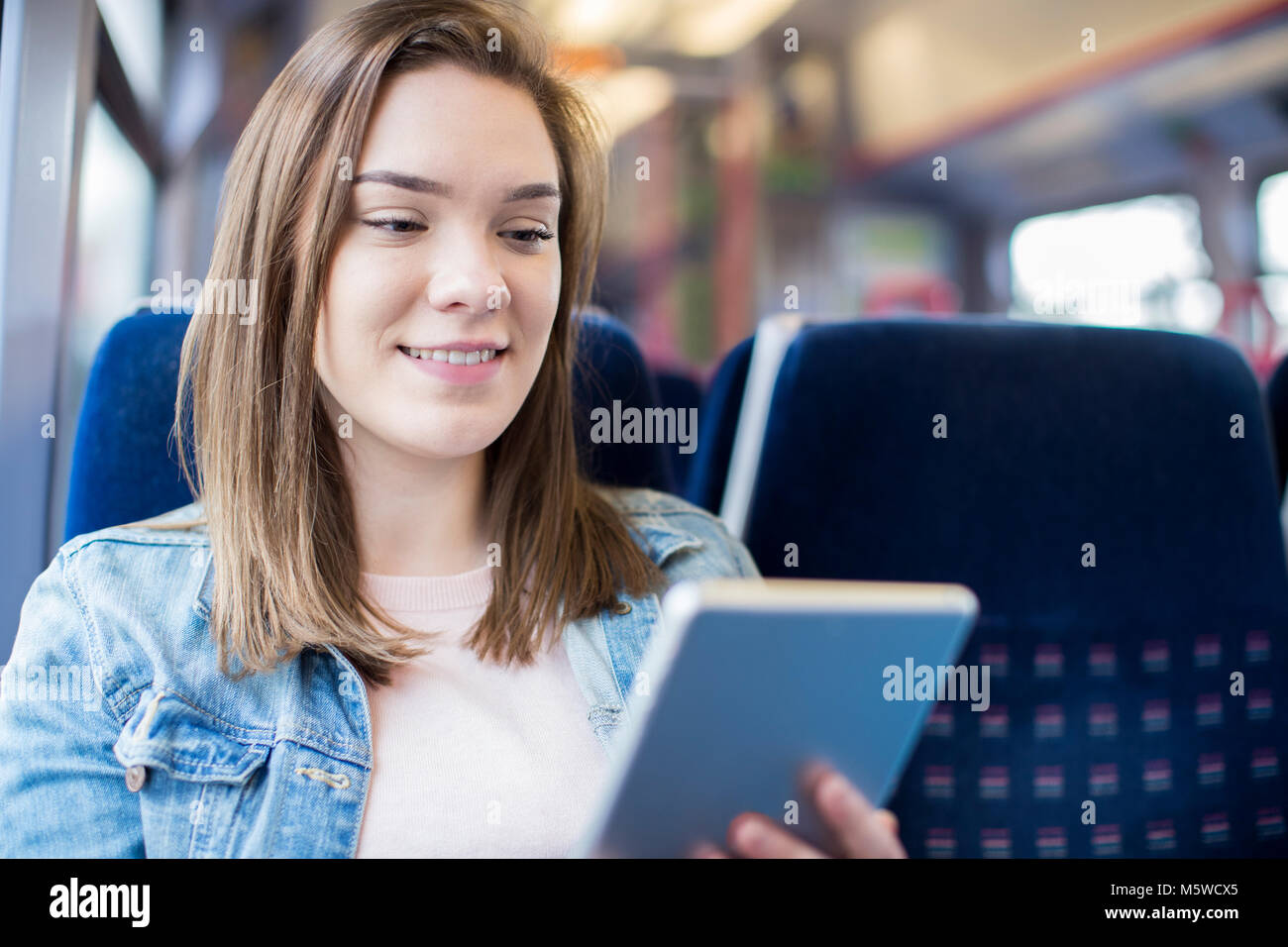 Junge Frau mit digitalen Tablet während der Zugfahrt Stockfoto