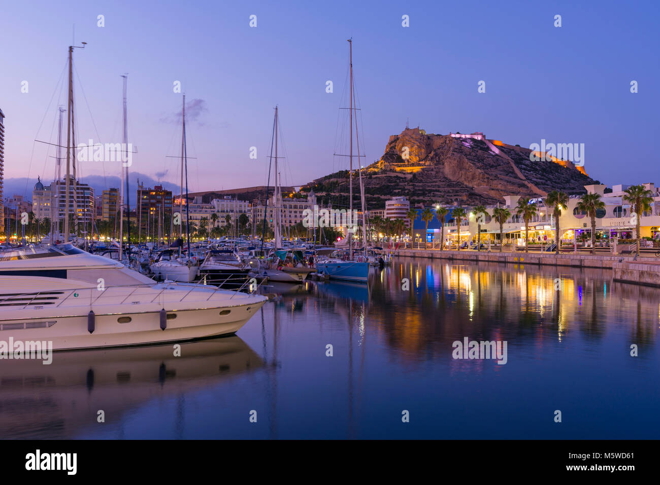 Der Yachthafen von Alicante in der Dämmerung mit der Burg Santa Barbara über, Spanien. Stockfoto