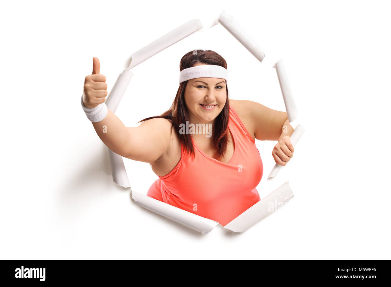 Übergewichtige Frau brechen durch Papier und ein "Daumen hoch" Geste Stockfoto