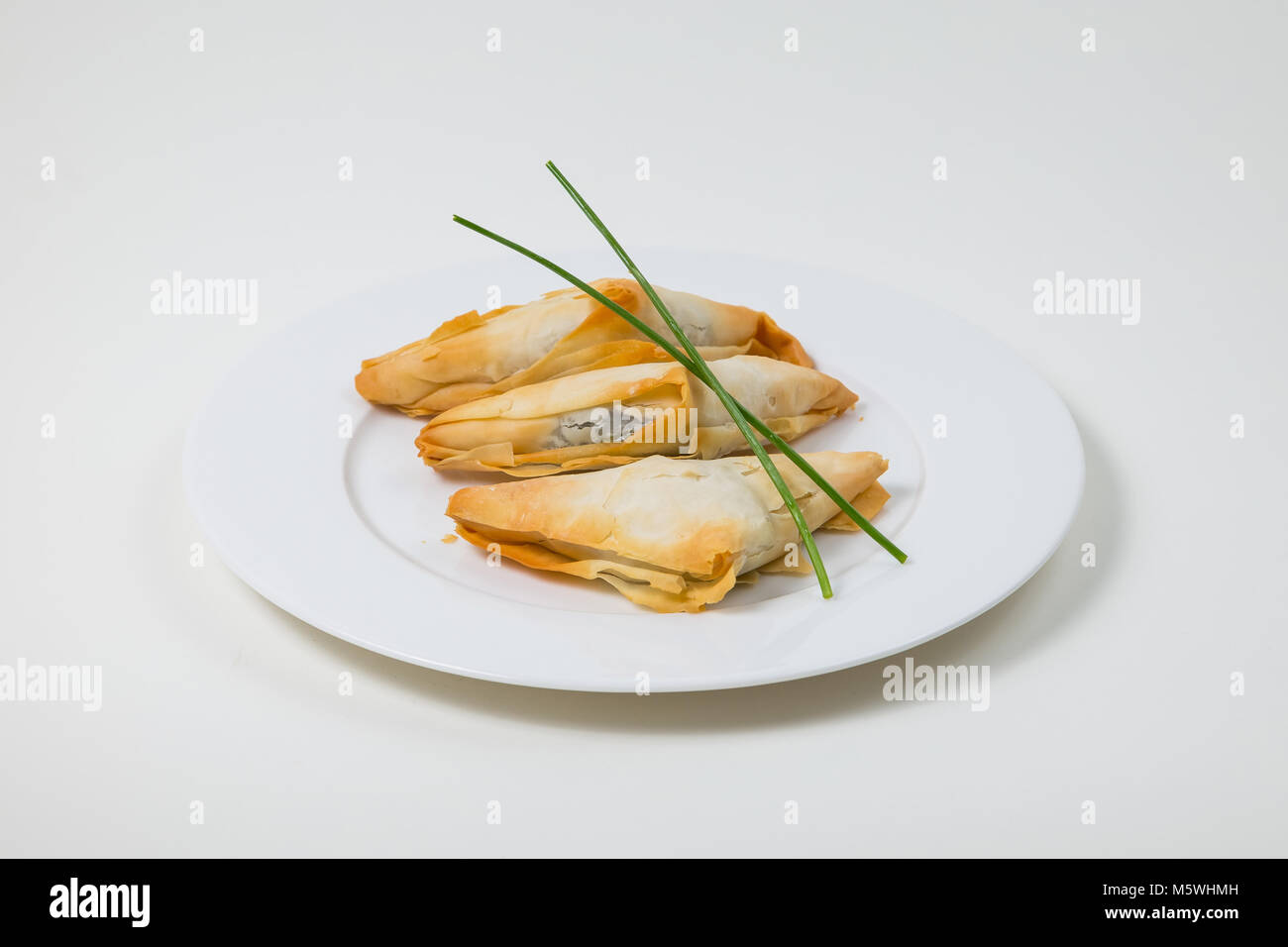 Samosa auf einem weißen Teller auf weißem Hintergrund Stockfoto