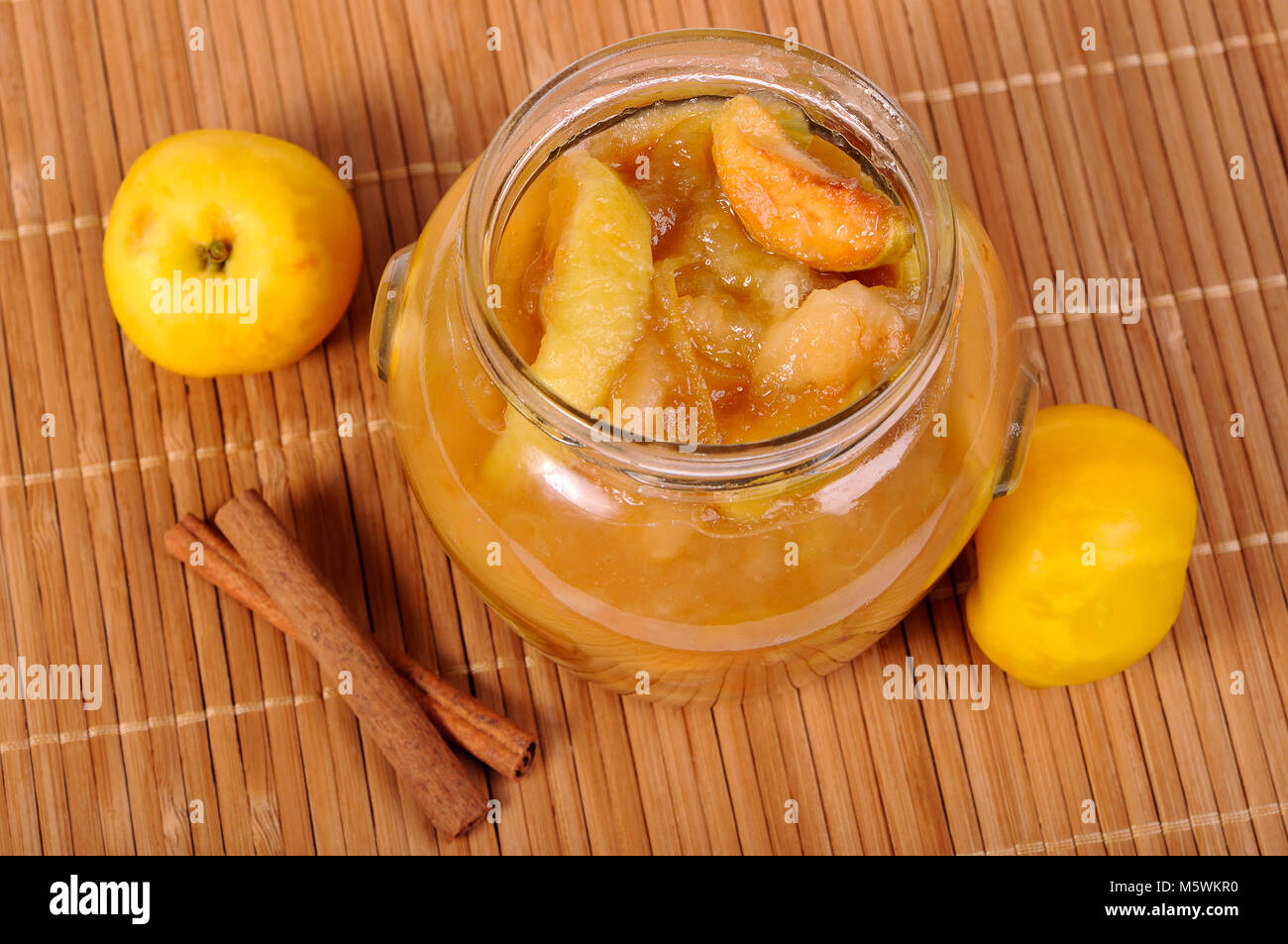 Glas Glas mit Apple Jam, gelbe Äpfel und Zimt Stockfoto
