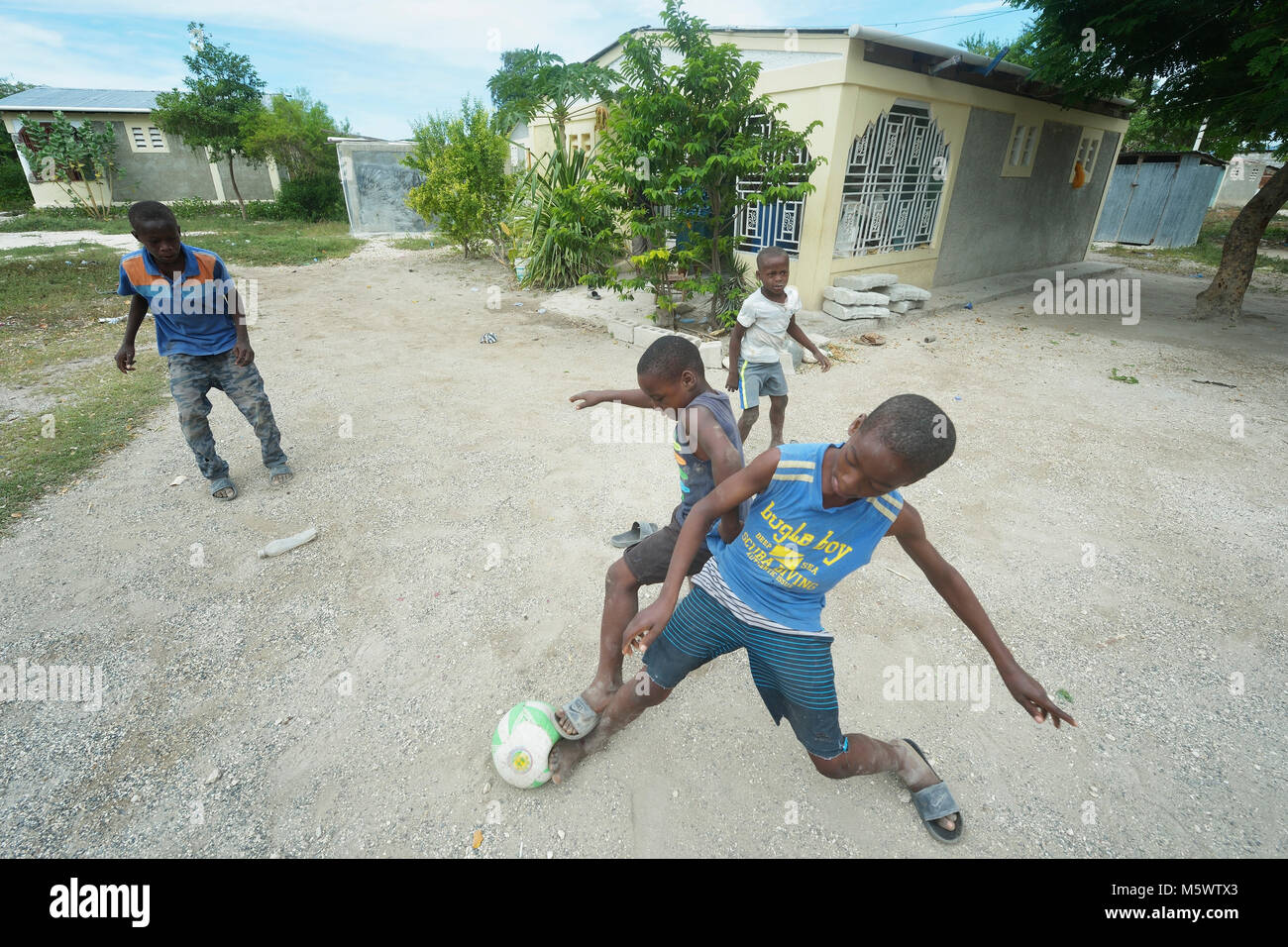 Kinder spielen vor einem Haus von Servicio Social de las Iglesis Dominicanas in der haitianischen Gemeinschaft von Ganthier. Stockfoto