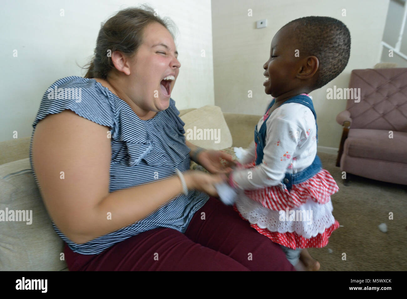 Krista Camp, ein Case Manager für Kirche World Service, spielt mit Rehema, ein Kind aus der Demokratischen Republik Kongo, bei einem Besuch in ihrer Fami Stockfoto