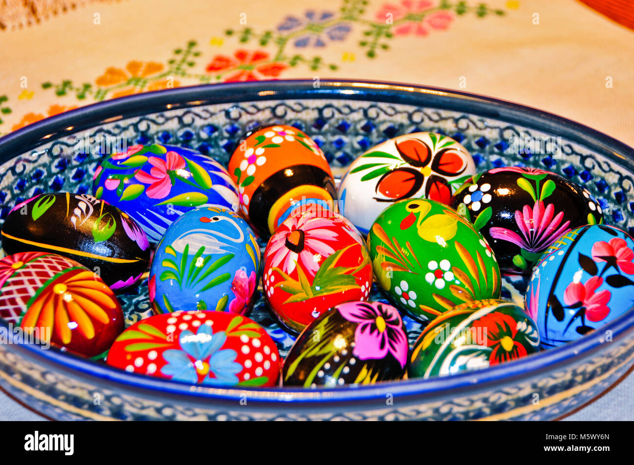 Bunt bemalte Ostereier aus Holz in eine keramische Schüssel Stockfoto
